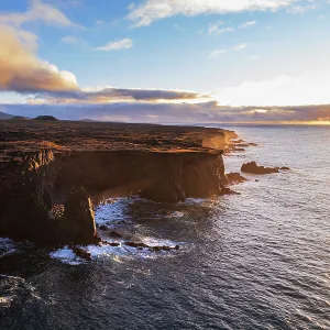 Aerial view of the orange Svortuloft lighthouse on top of the basalt cliffs at sunset, Snaefellsbaer, Snaefellsjokull National Park, Snaefellsens peninsula, Vesturland, West Iceland, Iceland, Polar Regions