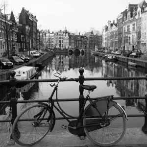 Black and white image of an old bicycle by the Singel canal, Amsterdam