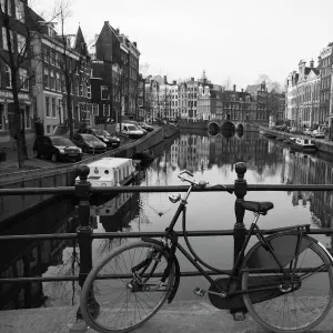 Black and white imge of an old bicycle by the Singel canal, Amsterdam, Netherlands