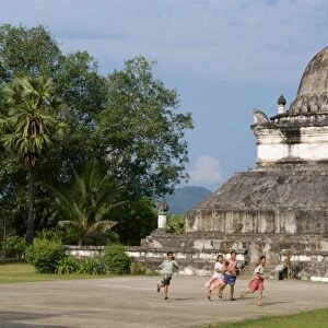 Children run in front of the Lotus Stupa at the Vixoun