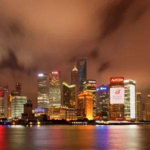 City skyline at night with Oriental Pearl Tower and Pudong skyscrapers across the Huangpu River