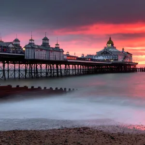 Eastbourne Pier against fiery red sky at sunrise, Eastbourne, East Sussex, England