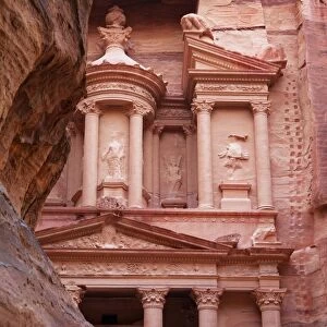 The facade of the Treasury (Al Khazneh) carved into the red rock with the Siq in the foreground, Petra, UNESCO World Heritage Site, Jordan, Middle East