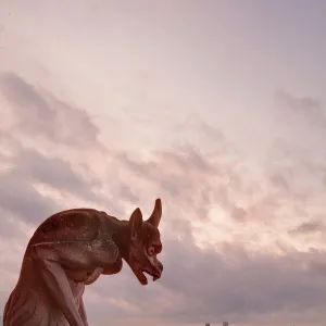 A gargoyle on Notre Dame de Paris cathedral looks over the city, Paris, France, Europe