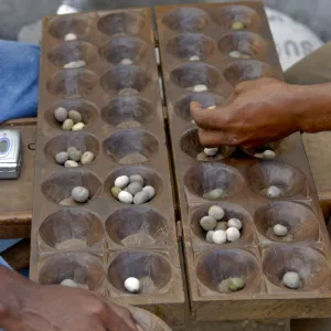 Men playing Kalah (Kalaha) (Mancala), a game in the mancala family, Moroni