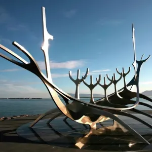 The midnight sun lights up the giant steel boat sculpture that stands on the waters edge at Reykjavik, Iceland