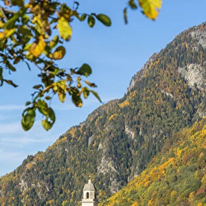 Old bell tower and church in the autumnal landscape, Soglio, Val Bregaglia