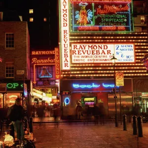 The Raymond Revuebar with neon signs in red light area at night, Soho, London