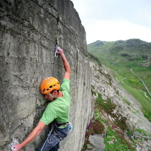 A rock climber makes a first ascent of on the cliffs above the Llanberis Pass