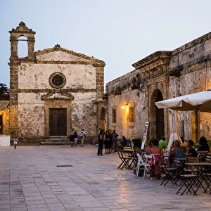 Tourist at a restaurant, Church of St Francis of Paolo in the main square, Marzamemi, Sicily, Italy, Europe