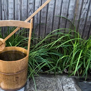 Traditional Japanese wooden bucket and ladle for washing sidewalk in a custom called uchimizu