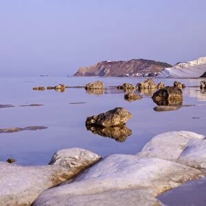White cliffs known as Scala dei Turchi frame the calm sea at dawn, Porto Empedocle
