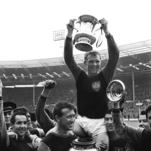 West Ham captain Bobby Moore lifts the FA Cup trophy in 1964