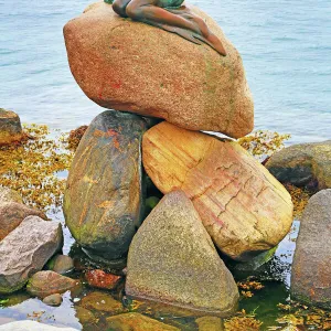 Little Mermaid statue sitting on rocks in Copenhagen, Denmark