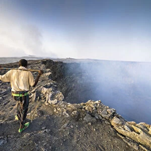 Afar man looking at the smoke coming out from Erta Ale volcano caldera