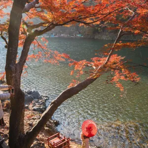 Arashiyama, Kyoto, Kyoto prefecture, Kansai region, Japan. Woman with red umbrella