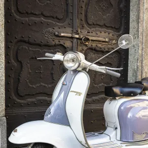 Bicolored Lambretta Innocenti scooter in front of ancient doorway, Morbegno, Sondrio