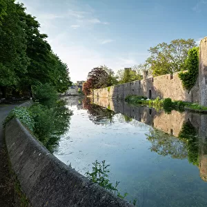 The Bishop's Palace reflected in its moat, Wells, Somerset, England. Spring (May) 2019