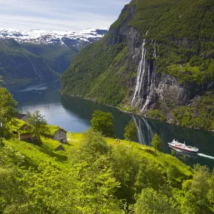 A car ferry passes beneath an old abandoned farm & the Seven Sisters waterfall, Geiranger