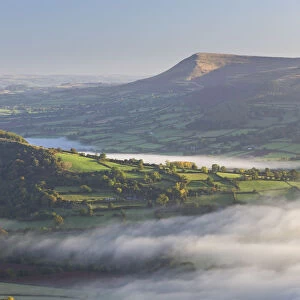 Early morning mist rolls over patchwork countryside in the Brecon Beacons National Park