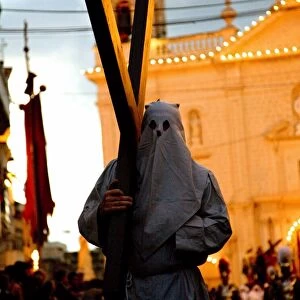 Europe, Malta, Qormi; A caped cross bearer walking barefoot during the Good Friday Processions