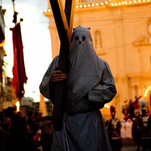 Europe, Malta, Qormi; A caped cross bearer walking barefoot during the Good Friday Processions