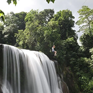 Girl on zip line over waterfall, Cascadas Pulhapanzak, Waterfalls, Honduras. MR