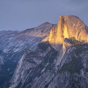 Golden evening sunlight lights up Half Dome above Yosemite Valley, Yosemite National Park, California, USA