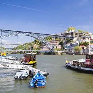 Portugal, Douro Litoral, Porto. Tourists boats on Douro River in the UNESCO listed