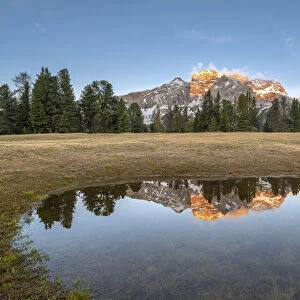 Prato Piazza/Pl√§tzwiese, Dolomites, South Tyrol, Italy. The Croda Rossa d'Ampezzo is reflected at sunrise in a pool on the Prato Piazza