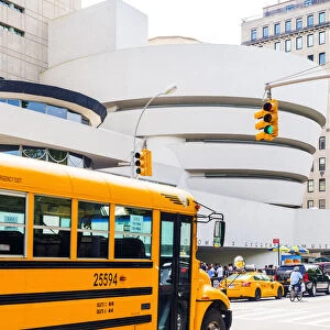 School bus passing the Solomon R Guggenheim museum, Manhattan, New York, USA