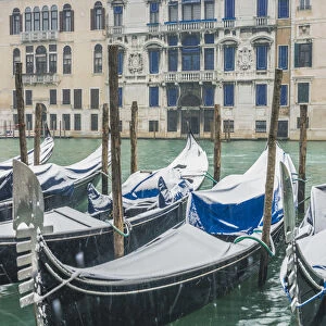 Venice, Veneto, Italy. Gondolas covered with snow along the Grand Canal (Canal Grande)