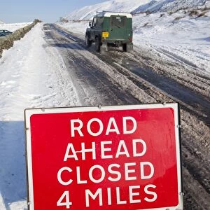 A road closed sign on top of Kirkstone Pass in the Lake District in Winter snows