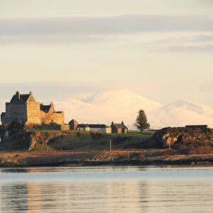 View of Duart Castle with snow covered mountains of mainland behind