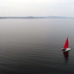 Aerial view shows a couple traveling on a sailing catamaran along the Yenisei River