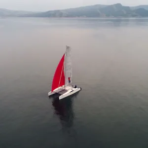 Aerial view shows a couple traveling on a sailing catamaran along the Yenisei River