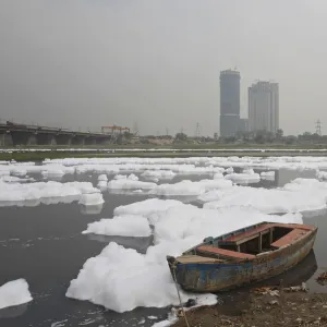 A boat is seen parked in the polluted water of the river Yamuna ahead of World Water Day