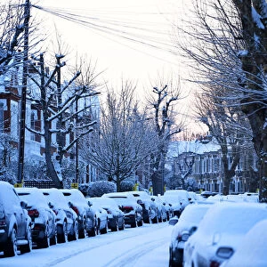 Cars are seen on a snow covered street in South London