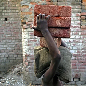 A child labourer carries bricks in Bihar-e-Sharif town