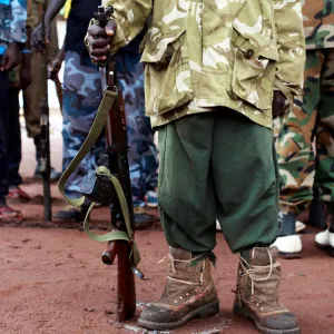 A former child soldier holds a gun as they participate in a child soldiers release ceremony