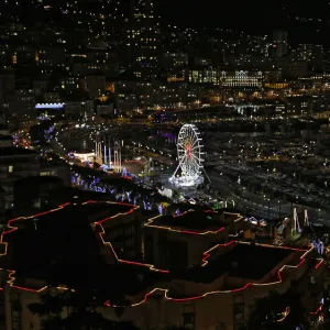 Christmas decorations and a Ferris wheel light the port of Monaco during holiday season