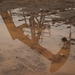 Coalbed methane well is seen reflected in a puddle in Jincheng