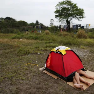 A Cuban migrant couple rests inside a tent at a provisional shelter in Paso Canoas