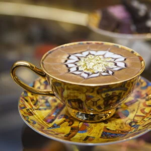 A cup of cappuccino called The Golden Horde with eatable gold flakes is ready for