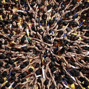 Devotees try to form a human pyramid to break a clay pot containing curd during celebrations