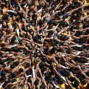 Devotees try to form a human pyramid to break a clay pot containing curd during celebrations