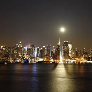 File photo of a full moon rising over the New York skyline above 42nd Street, seen