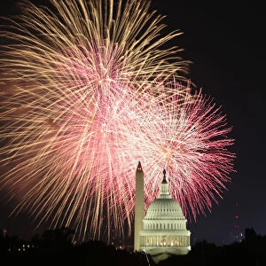 Fireworks explode over the United States Capitol dome and Washington Monument on Independence