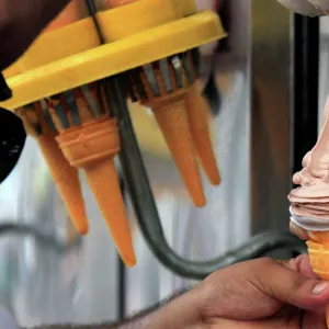 An ice cream vendor fills a cone with chocolate ice cream in Peshawar