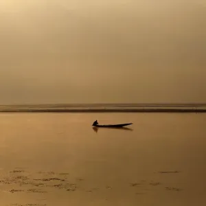 A Kashmiri man catches fish in Dal Lake on a cold winter morning Print